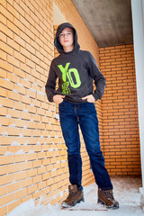 Kirov, Russia - January 19, 2019: Teenager boy dressed in black sweater standing outdoors during winter walk