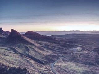 Spring view of Quiraing mountains with blue sky, Isle of Skye. Sharp rocky mountains above vallley.