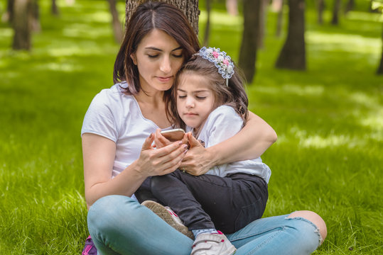 mom and girl look at photos after selfie
