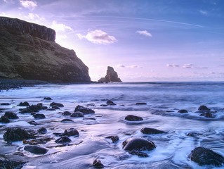 Blue atmosphere in windless evening at sea. Big rounded boulders