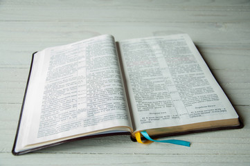 Fototapeta premium An open book on a wooden table. Bible on wooden background