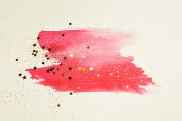 Golden glitter and glittering stars on abstract pink watercolor splash in vintage nostalgic colors.