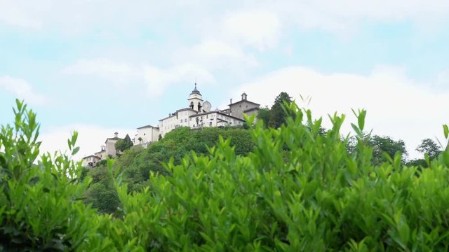 A view from the distance of the Sacred Mountain of Varallo, a christian devotional complex, a unesco world heritage si in Italy. Zoom out 4k footage