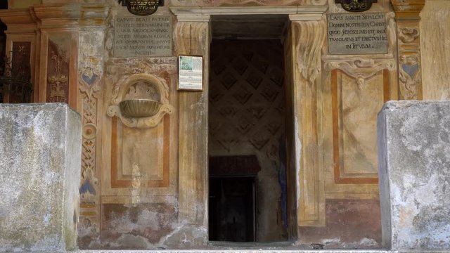 Entrance of Holy Sepulchre at Mountain of Varallo, a christian devotional complex, a unesco world heritage site close to river Sesia near the town of Varallo Sesia in Italy. Zoom out 4k footage