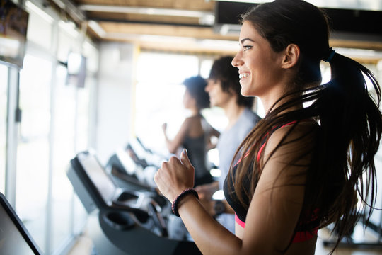 Fit People Running In Machine Treadmill At Fitness Gym