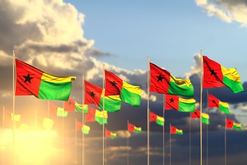 nice many Guinea-Bissau flags on sunset placed in row with bokeh and space for text - any feast flag 3d illustration..