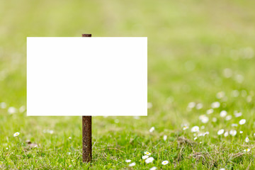 Empty sign plate in the green grass nature meadow.