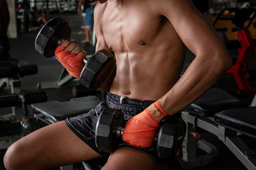 Fototapeta na wymiar Thai boxer sport man doing exercise with dumbbells.