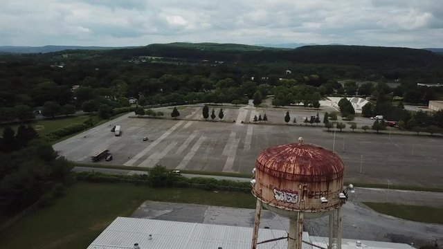 This is a drone shot circling a water tower in upstate, New York.