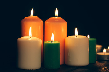 Fototapeta na wymiar candles burning in darkness over black background. commemoration concept.