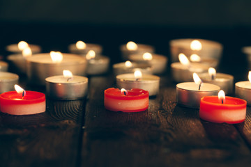 candles burning in darkness over black background. commemoration concept.
