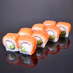 Philadelphia roll sushi with salmon, avocado and cream cheese on black background for menu. Japanese food