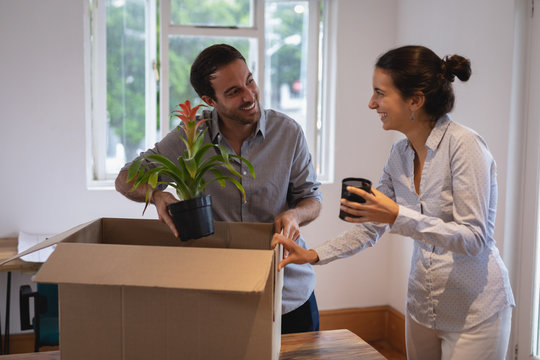 Business people interacting with each other while packing cardboard boxes
