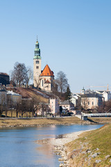 The view along the Salzach River in Salzburg, Austria.  In the background can be seen the "Mullner Steg" Bridge and the the parish church Mulln, a Roman Catholic church.