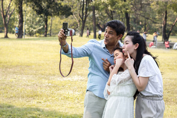 Asian families are taking family photos in a public garden.