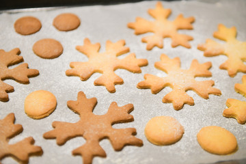Fototapeta na wymiar Snowflake Cookies. Snowflake shaped Gingerbread cookies stacked and tied with a gold bow.