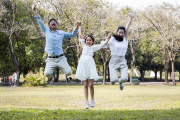 Asian family jumping in the park.