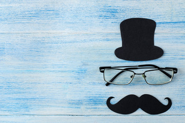 happy father's day. decorative men's hat, mustache and glasses on a light blue wooden background....