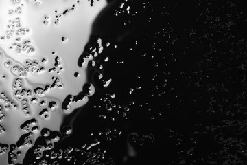 Obraz premium Water puddle and droplets isolated on black background and texture, top view