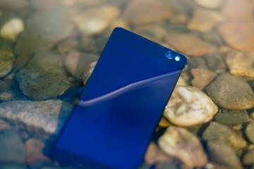 modern smartphone closeup thrown into water