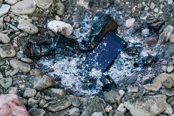 modern smartphone thrown into bonfire
