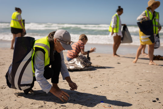 Volunteers cleaning beach on a sunny day