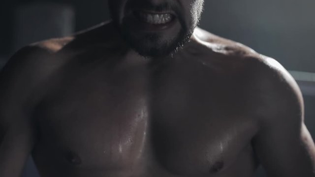 Angry male boxer standing on the boxing ring. Close up.