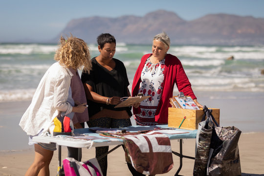 Volunteers discussing over clipboard on the beach