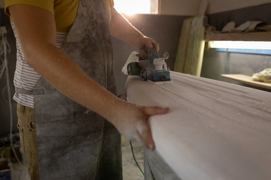 Man making surfboard in a workshop