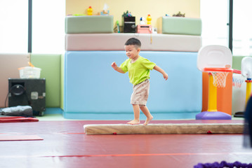 Little toddler boy working out at the indoor gym excercise