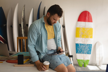 Man using laptop while having coffee in a workshop 