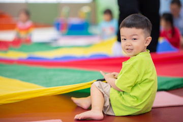 Little toddler boy working out at the indoor gym excercise