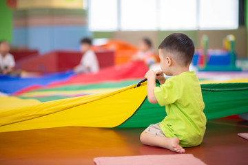 Little toddler boy working out at the indoor gym excercise