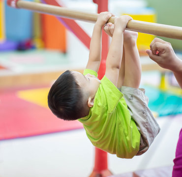 Little toddler boy working out at the indoor gym excercise