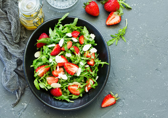 Fresh salad with arugula, strawberries and almonds. Selective focus.