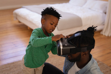 Son fixing virtual reality headset to his father at home