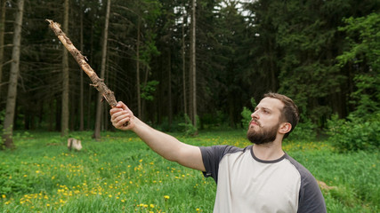Lumberjack in the woods with an ax. Brutal bearded man with beard and moustache on summer day, sunny forest. Handsome man, hipster, lumberjack. Attractive bearded male outdoors in summer. 