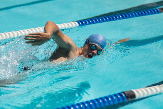Young Caucasian Male Swimmer Swimming Freestyle In Swimming Pool