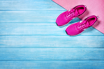 Fitness shoes over blue planks background. Sport shoes and accessories for sports activities on...