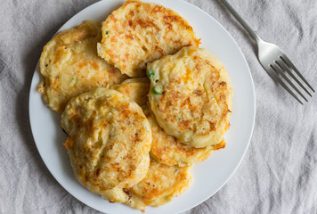 Potato cakes heaped on white plate with serving fork