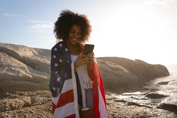 Woman standing and using mobile phone near sea side 