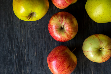 Red and green apples on a dark wood background