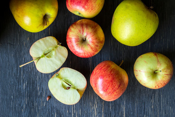 Red and green apples on a dark wood background - overhead view