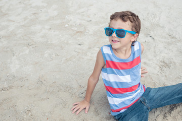 One happy little boy playing on the beach at the day time.