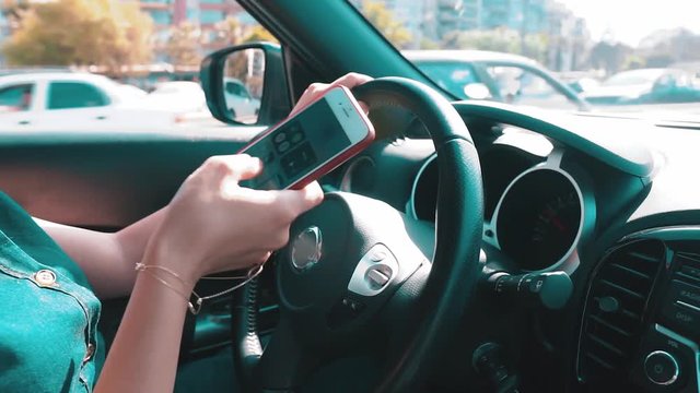 Woman using mobile phone when she is driving car. Dangerous on traffic. Distracted female driver on road, texting on automobile. 