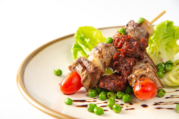 grilled meat and vegetables on plate isolated on white