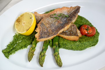fish on a plate with lemon and parsley