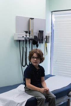 Caucasian boy patient sitting at bed  in clinic 