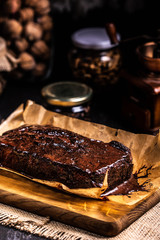 Brownie in chocolate syrup on baking paper.