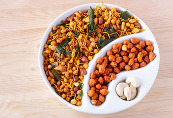 South indian spicy crunchy mix Nimco or Namkeen and spicy coated peanut white bowl wooden background isolated.